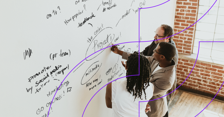 a group of people writing on a whiteboard