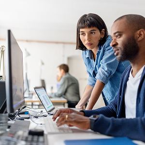 a man and a woman looking at a computer screen